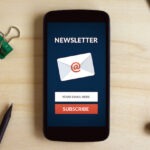 Subscribe newsletter concept on smart phone screen on wooden desk